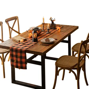 Orange and black buffalo plaid Halloween table runner on a rustic wooden dining table