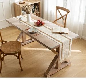Detailed texture of bohemian woven table runner with elegant tassels on wooden table