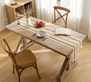 Bohemian woven table runner with hollow design and fringe on a wooden dining table