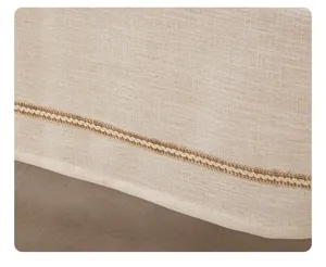 Close-up of beige linen-like tablecloth edge with decorative wavy hemp rope trim