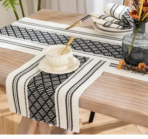 Bohemian woven table runner with black and white geometric patterns and fringe detail