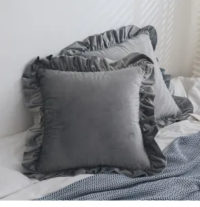 Detailansicht der weichen Samtstruktur und eleganten Rüschen eines grauen Kissenbezugs