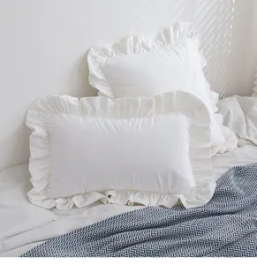 Kopfkissenbezug aus weißem Samt mit elegantem Rüschenrand auf gemütlichem Bett.