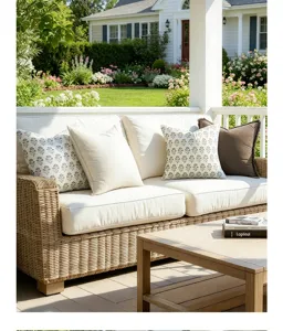 Vintage floral pattern on faux linen cushion covers on an outdoor patio wicker sofa.