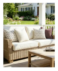 Close-up view of vintage floral and solid throw pillow covers on a white wicker sofa