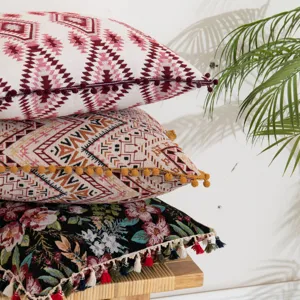 Stack of bohemian ethnic style decorative pillow covers with colorful tassel trim details