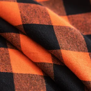 Primer plano de la textura de tela a cuadros naranja y negro para una funda de sofá.