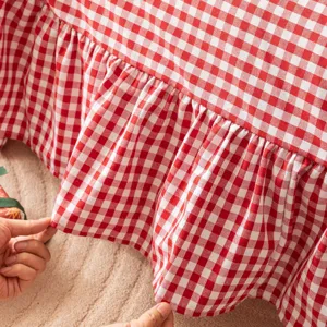 Detail of red and white checkered sofa cover with elegant ruffled edges