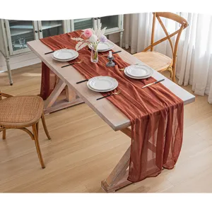 Camino de mesa de gasa color terracota cubriendo con elegancia una mesa de comedor