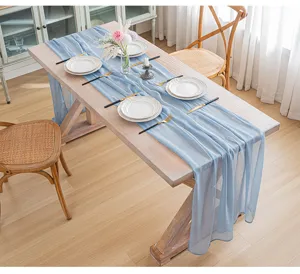 Elegante camino de mesa transparente azul claro sobre mesa de comedor de madera para bodas