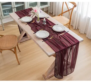 Elegante camino de mesa de gasa burdeos sobre mesa de madera para fiestas.