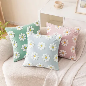 Set of three colorful velvet daisy embroidered throw pillow covers displayed on a white sofa