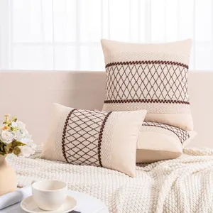 Set of beige cotton woven pillow covers featuring brown diamond embroidery patterns