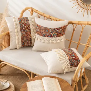 Διακοσμητικές μαξιλαροθήκες boho στυλ με φούντες και σχέδια λαχούρι σε καναπέ από ρατάν