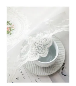 Primer plano del elegante bordado de encaje floral blanco en cortina de cocina
