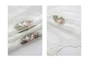 Detalle de cerca del bordado floral y el encaje en cortina corta blanca de cocina.