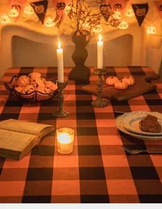 Decorazione tavola Halloween con tovaglia a scacchi arancione e nero e candele