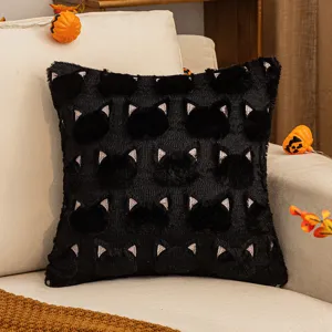 Housse de coussin chat noir d'Halloween avec broderies sur un canapé beige clair