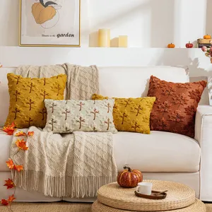 Autumn maple leaf embroidered plush pillow covers in warm seasonal tones on a sofa