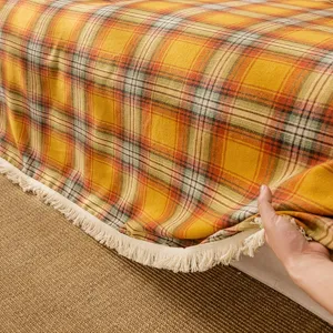 Copridivano a quadretti arancione retrò con nappe decoro casa autunnale