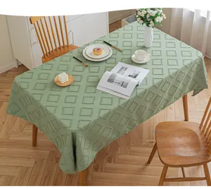 Sage green rectangular tablecloth with 3D geometric cut-flower texture on a dining table.