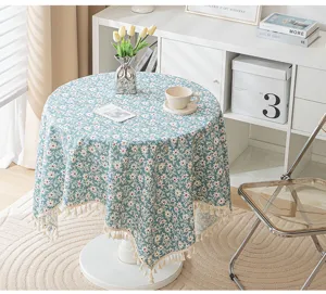 Detailed view of a blue daisy floral tablecloth with elegant fringe tassels in a room