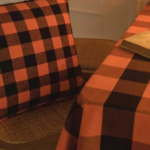 Tovaglia e cuscino a scacchi arancioni e neri per decorazioni festive di Halloween.