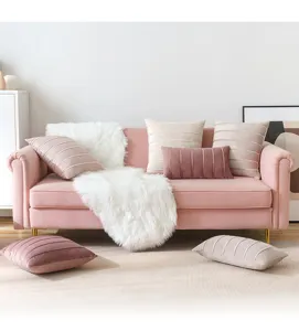 Luxury velvet striped decorative cushion covers displayed on a cozy modern pink sofa