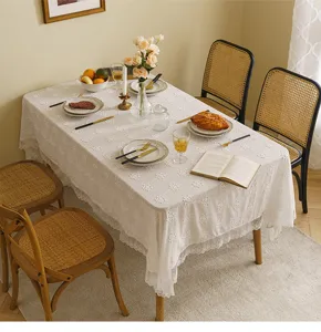 Detailed view of white 3D floral lace tablecloth on a French style dining table