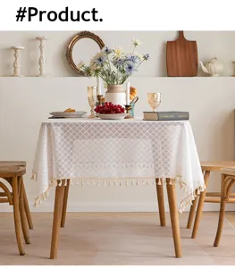 Detail view of elegant white French lace tablecloth with intricate tassel fringe