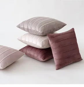 Close-up detail of soft velvet throw pillow covers featuring decorative striped binding