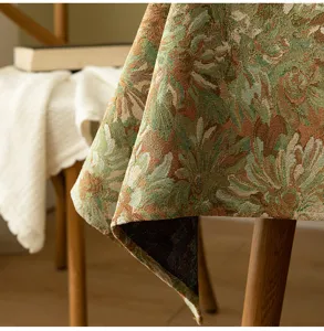 Close-up of vintage floral jacquard tablecloth with intricate woven texture and fringe