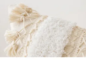 Detailed view of tufted fabric and cream tassels on a boho Moroccan style pillow cover