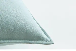Detalle macro de la funda de almohada de cuero PU azul menta con textura mate y costuras