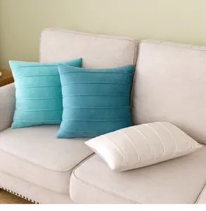 Detailed view of velvet throw pillow covers with horizontal striped pleats on a sofa