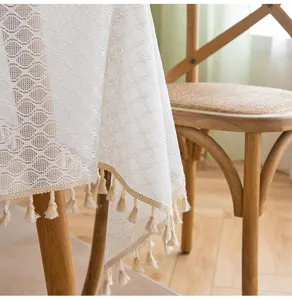 Detail of white lace tablecloth showing intricate patterns and delicate tassel fringe.