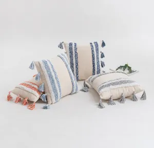Four bohemian tufted cushion covers with ethnic tassels shown in a clean lifestyle set