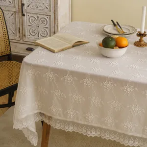 Elegant white lace tablecloth with floral embroidery and scalloped edges for dining