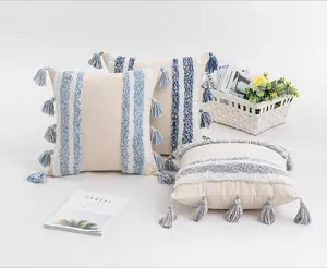 Boho-Kissenbezüge mit blauen Streifen und dekorativen Quasten auf weißem Hintergrund