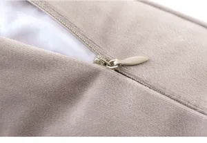 Macro view of the high-quality invisible zipper on a soft taupe velvet pillow cover