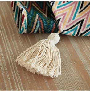 Dettaglio ravvicinato del runner da tavola bohémien con motivi colorati e nappe.