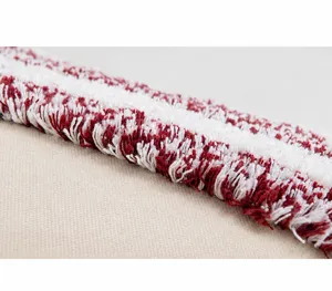 Macro detail of the tufted texture and red woven patterns on a Bohemian cushion cover