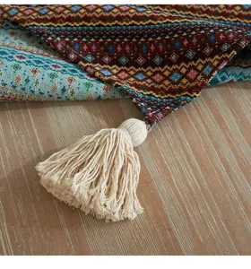 Primo piano di un runner da tavola intrecciato bohémien con nappa decorativa beige