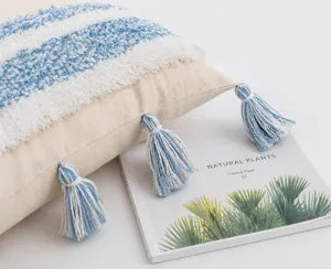Detailed macro shot of handmade cotton tassels on a tufted boho style pillow cover