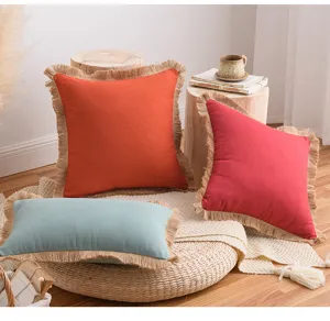 Vue détaillée de housses de coussin en coton et lin bohème avec franges sur tapis tissé