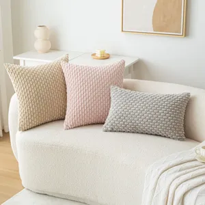 Housses de coussin en velours côtelé beige, rose et gris sur un canapé blanc