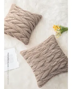 Detailweergave van taupe gevlochten kussenhoezen van imitatiekonijnenbont op bont.