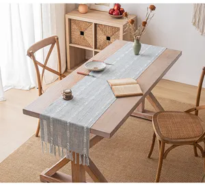 Eleganter minimalistischer gestreifter Tischläufer mit Quasten in einem gemütlichen Esszimmer
