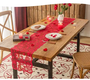 Lifestyle-Ansicht des roten Herz-Spitzenläufers auf einem Holztisch mit Kerzenlicht