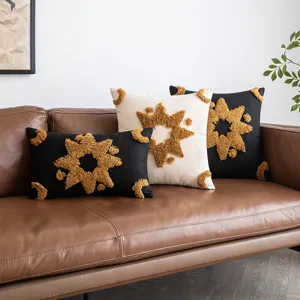 Fodere per cuscini ricamate con stella geometrica su un divano in pelle moderno
